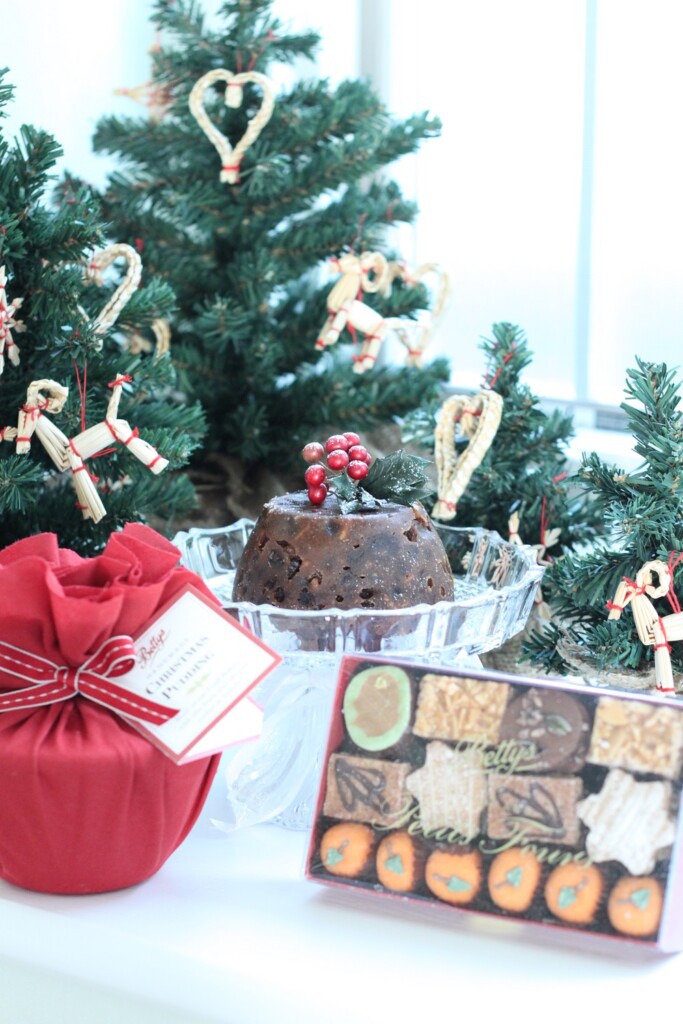 クリスマスツリーを背景に、クリスマスプディングとクッキー