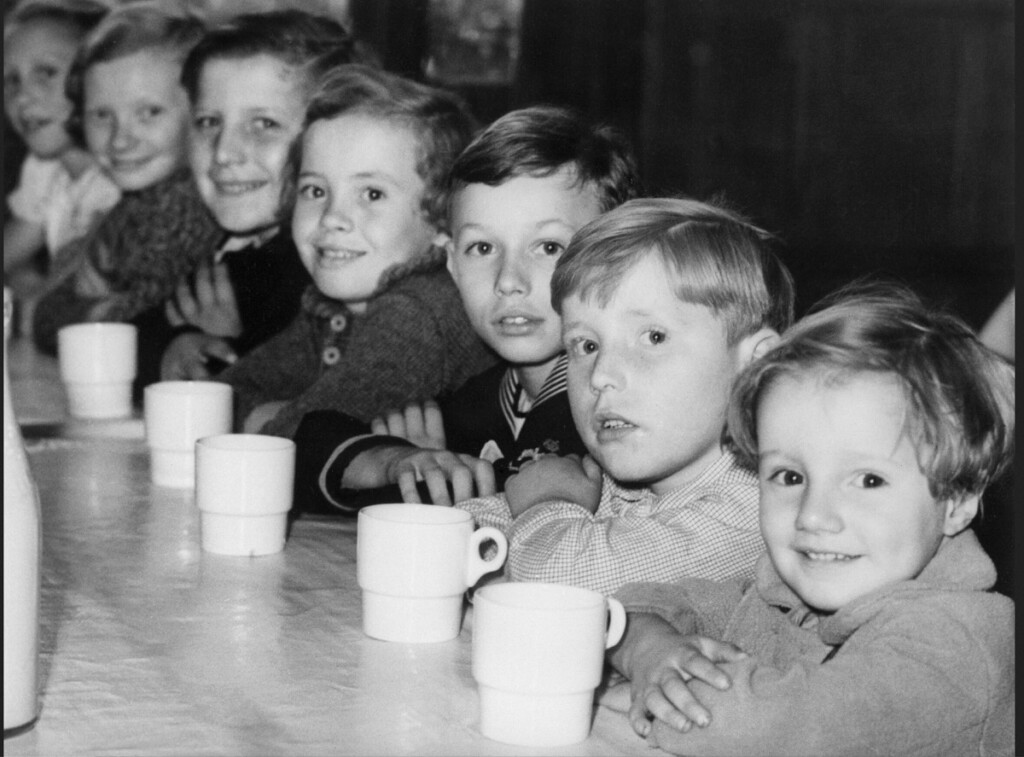 お茶の時間、テーブルにカップを並べて待つ子供たち