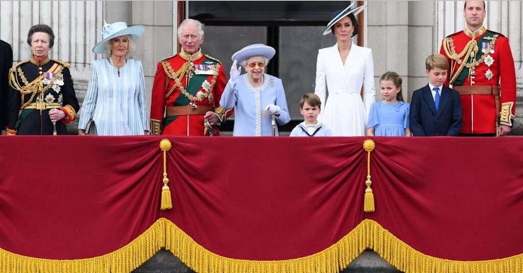 バッキンガム宮殿のバルコニーに立ち手を振るエリザベス女王と王室の方々