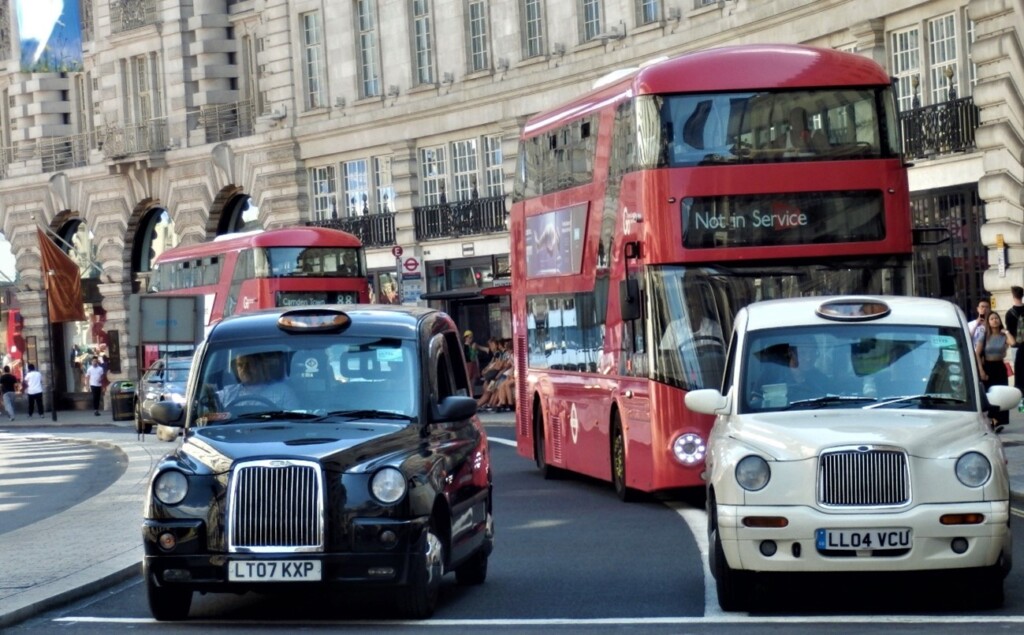 街中を走るロンドンタクシーと2階建てのロンドンバス