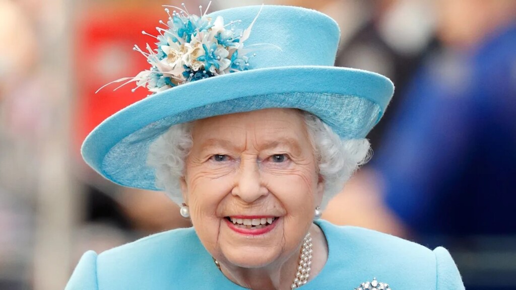 薄いブルーの洋服とハットをかぶった笑顔のエリザベス女王