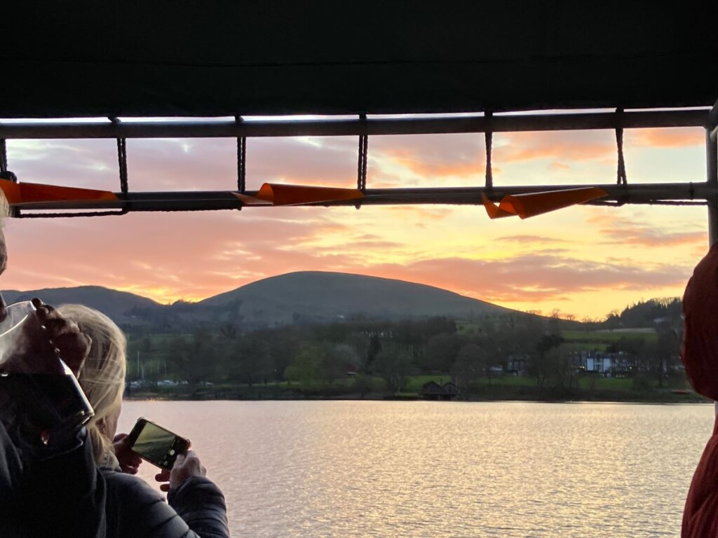 アルズウォーターの船の上から眺める川と夕陽